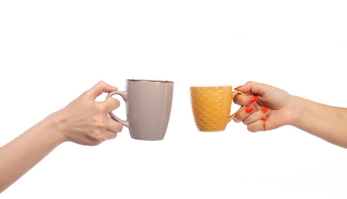 a front view female hands holding different colored cups on the