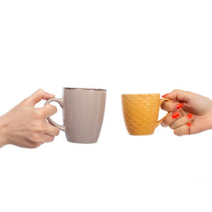 a front view female hands holding different colored cups on the